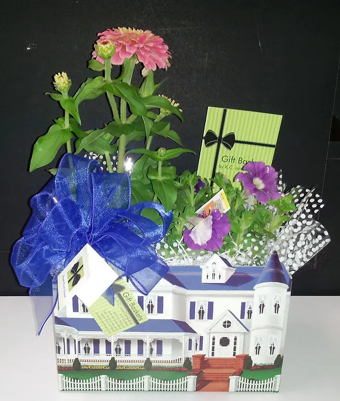 A decorative flower arrangement in a box, elegantly tied with a blue ribbon.